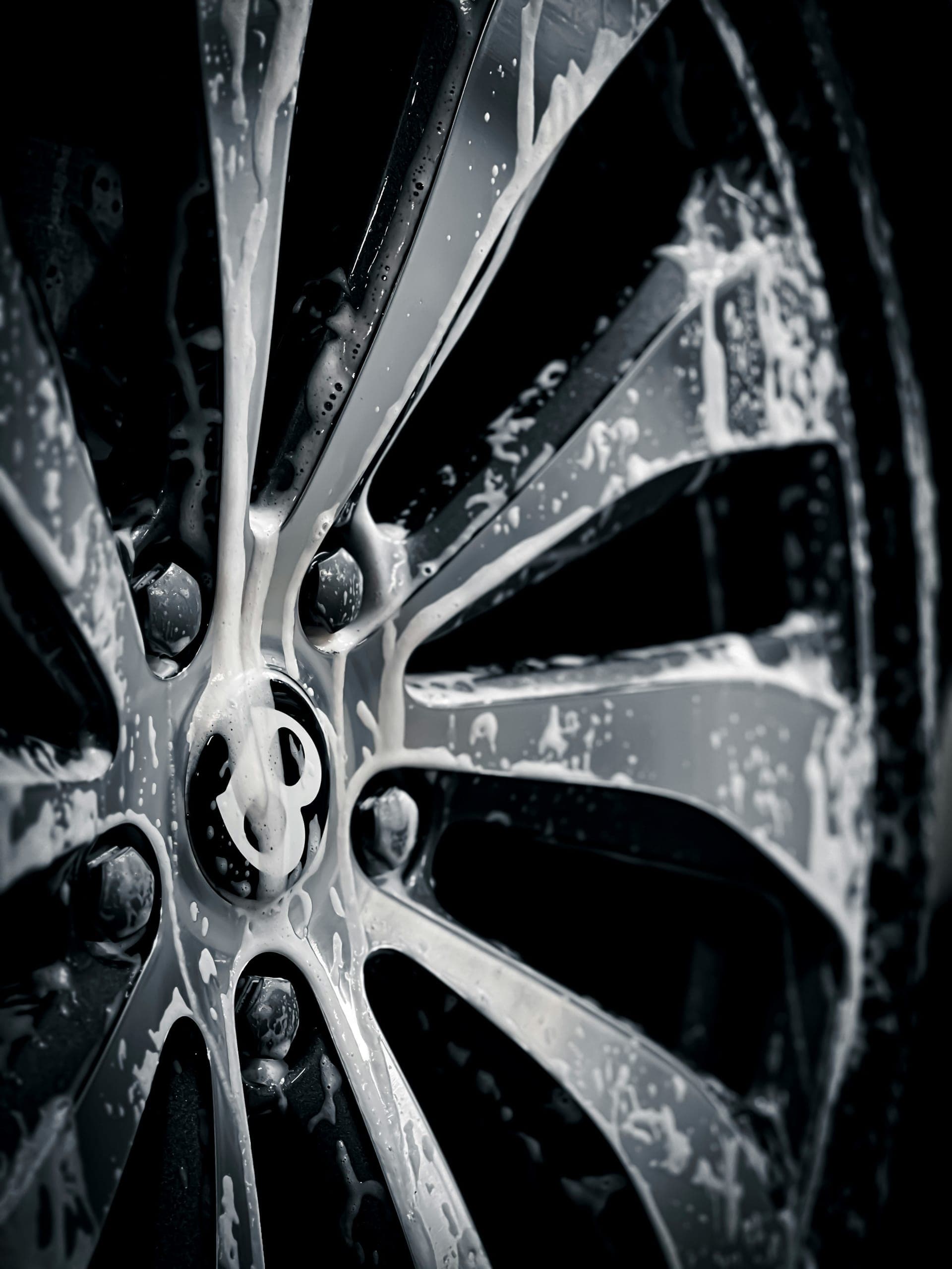 Foam running across a vehicle wheel during car detailing on Lāna'i